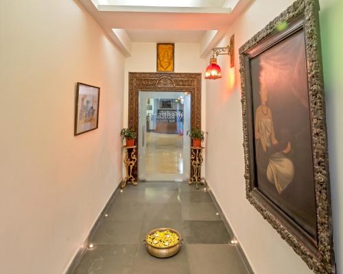 a hallway with a painting and a bowl on the floor at Club Mahindra Mashobra in Mashobra