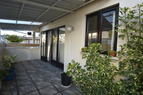 a porch of a house with plants next to it at Maison LE GLAS in Curepipe
