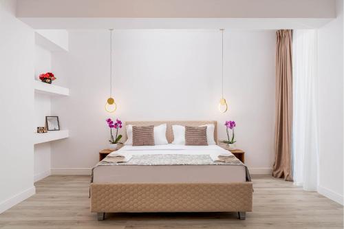 a bedroom with a large bed with white walls at Hotel Boutique Tunari in Tunari