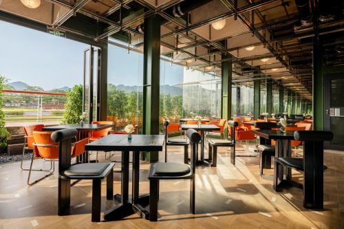 a restaurant with tables and chairs and large windows at private soup holiday villa by the sea in Dapeng