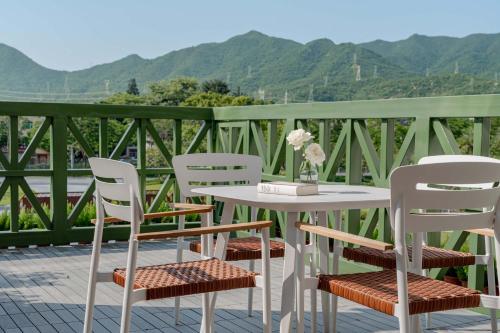 a table and chairs on a patio with mountains in the background at private soup holiday villa by the sea in Dapeng