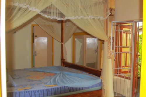 a bedroom with a canopy bed with curtains at Familyhouse in Negombo