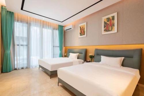 a hotel room with two beds and a window at Sanya Haitang Bay Ocean State International Resort Hotel in Sanya