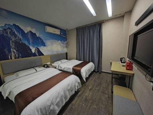 a hotel room with two beds and a flat screen tv at Thank Inn Hotel He'nan Xinxiang Changyuan Bo'ai Road in Changyuan
