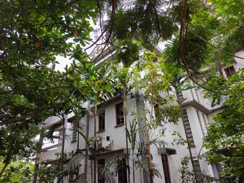 a white building with trees in front of it at Sunsea Palacio Residency in Kuilapayam