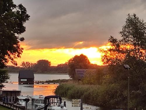 a sunset over a body of water with boats at Veronika in Wesenberg