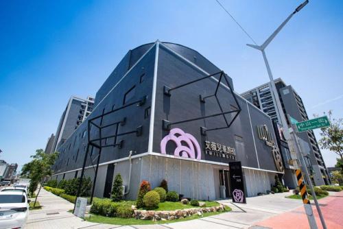 a black building with a pink sign on it at 艾薇兒車旅宿 in Hu-k'ou