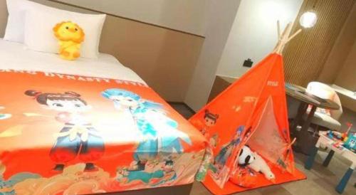 a bedroom with a bed and a toy tent at Wanda JIN Baise in Baise