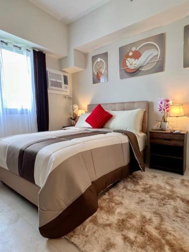 a bedroom with a large bed and a window at Cebu Minimalism 1 Bedroom in Cebu City