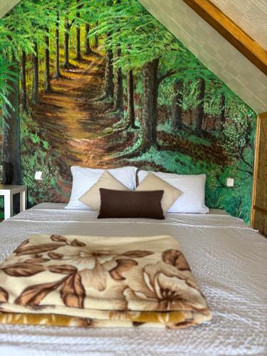 a bed with a painting of a forest at Zasavčanka in Sremska Mitrovica
