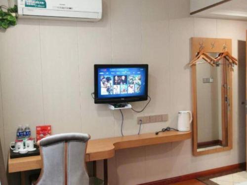 a tv on a wall in a room at GreenTree Inn Wuxi Xinwu District Meicun Town Taibo Avenue in Wuxi