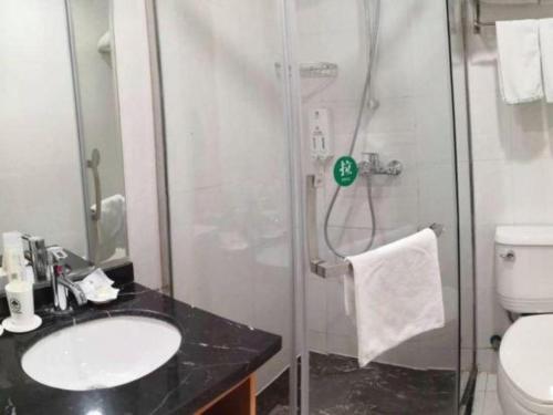 a bathroom with a shower and a sink and a toilet at GreenTree Inn Wuxi Xinwu District Meicun Town Taibo Avenue in Wuxi