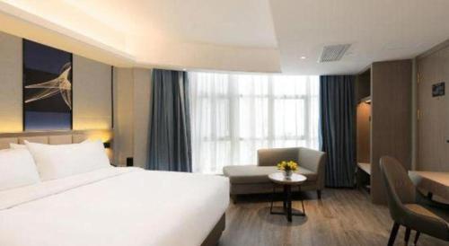 a hotel room with a large white bed and a desk at Nanning Prince Hotel in Nanning