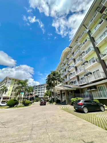 a parking lot in front of a large building at Fully equipped Studio unit near Mactan Airport with WIFI, Pool & Gym Access in Mactan
