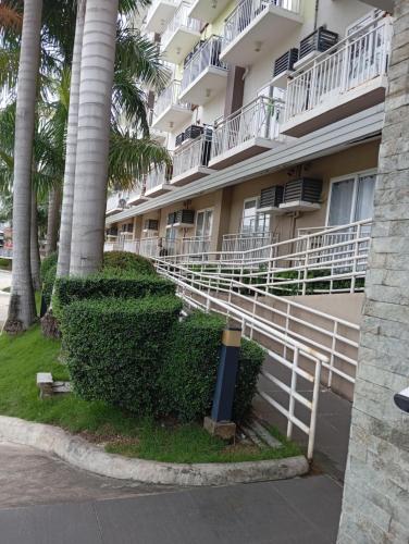 a building with palm trees in front of it at Fully equipped Studio unit near Mactan Airport with WIFI, Pool & Gym Access in Mactan