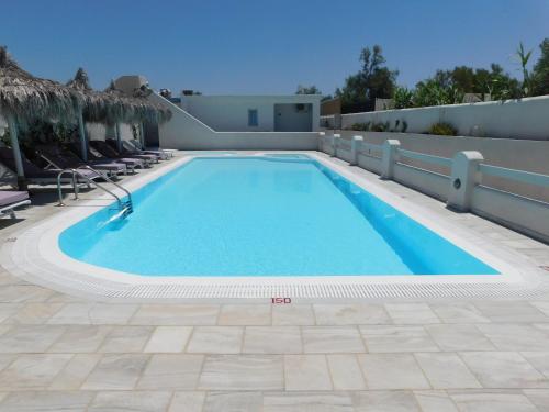 a swimming pool in a resort with chairs at Perissa South Beach Suites in Perissa