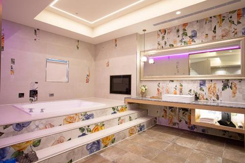 a large bathroom with a tub and a sink at 艾薇兒車旅宿 in Hu-k'ou