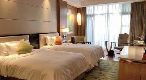 a hotel room with two beds and a table at Dusit D2 Binhu Changzhou Hotel in Changzhou