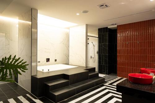 a bathroom with a black and white tile floor and a tub at 艾薇兒車旅宿 in Hu-k'ou