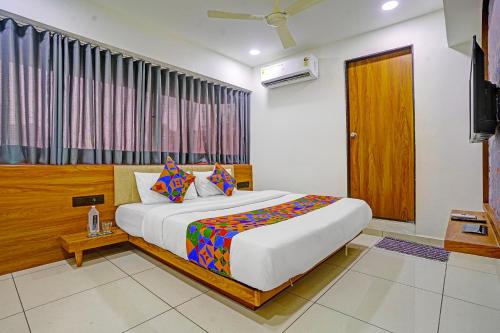 a bedroom with a large bed in a room at FabHotel Royal Manor - Hospital Chowk in Rajkot