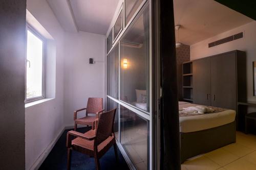 a small room with two chairs and a bed at Thilhara Colombo in Colombo