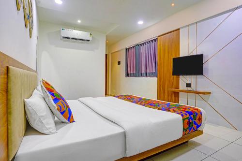 a hotel room with a bed and a tv at FabHotel Royal Manor - Hospital Chowk in Rajkot