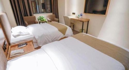 a hotel room with two beds and a desk at GreenTree Inn Hefei Chenghuangmiao San Xiao Kou Subway Station Hotel in Hefei