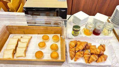 two plastic trays filled with bread and croissants on a table at Grand Park Hotel Panex Chiba in Chiba