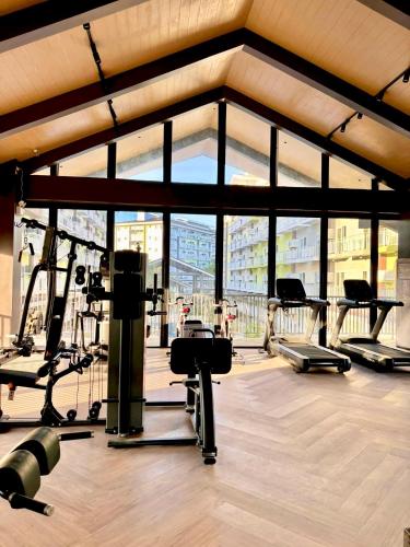 a gym with several tread machines and a large window at Fully equipped Studio unit near Mactan Airport with WIFI, Pool & Gym Access in Mactan