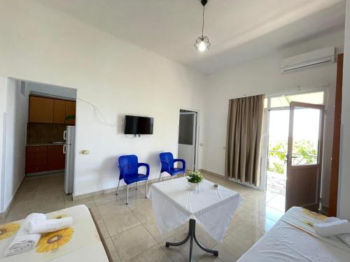 a living room with a table and two blue chairs at Albert Guest House in Borsh