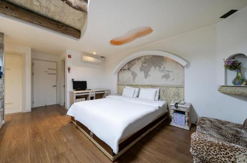 a bedroom with a large white bed and a couch at Daejeon Yongjeon I Hotel in Daejeon