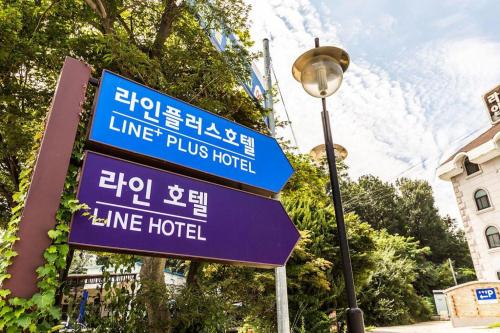 a sign for a line hotel next to a street light at Line Plus Hotel in Gimpo