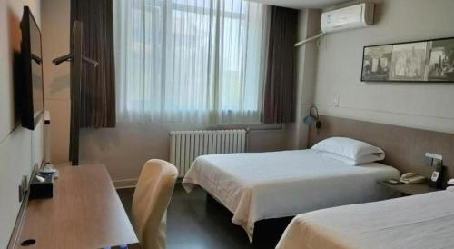 a hotel room with two beds and a table at Jinjiang Inn Xi'an Zhonglou North Street Metro Station in Xi'an