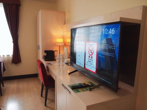 a large flat screen tv on a table in a hotel room at Hotel Monterey La Soeur Osaka in Osaka