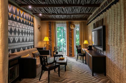 a living room with a couch and a tv at Bambara Hotel in Felsőtárkány