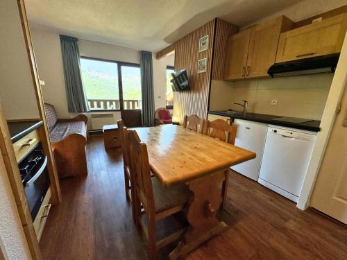une cuisine avec une table en bois et une salle à manger dans l'établissement Résidence Necou - Appartement 4 persons en bord de pistes MAE-5094, aux Menuires