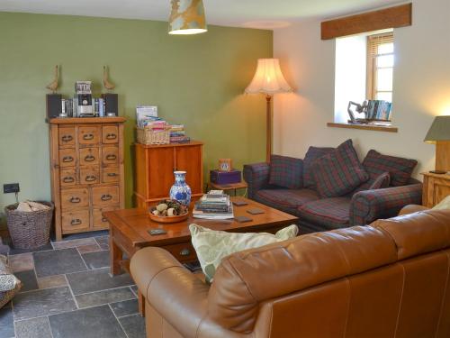 una sala de estar con un sofá y una mesa en Hen Dy Goits, en Llangadwaladr