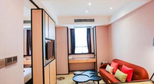 a living room with a couch and a television at Cozy Hotel Xiamen in Xiamen