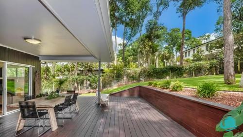 a patio with a table and chairs on a wooden deck at Stay A While at Murrays Beach in Cams Wharf