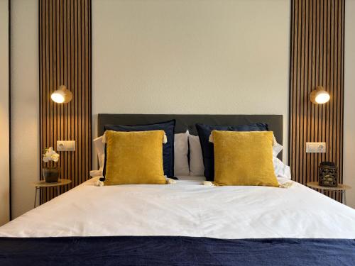 a bedroom with a bed with blue and yellow pillows at Apartamento Cabo de Ajo in Ajo