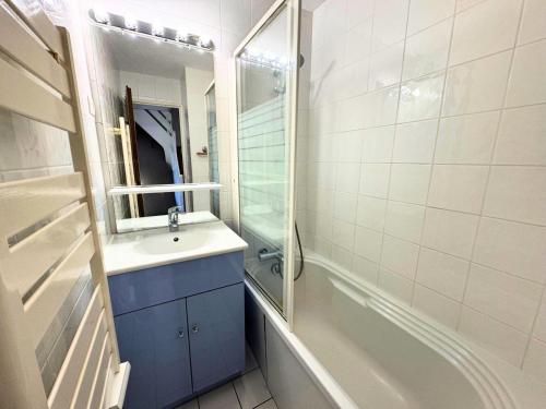 une salle de bain avec un lavabo, un miroir et une baignoire dans l'établissement Résidence Necou - Grand duplex rénové pour 6 personnes MAE-3904, aux Menuires