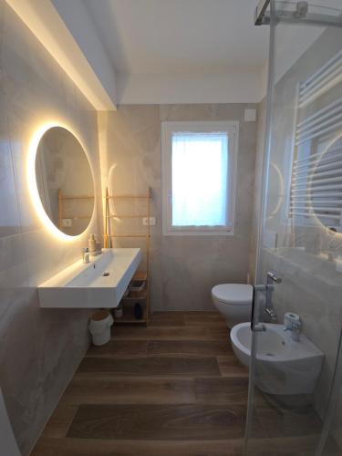 a bathroom with a sink and a toilet and a mirror at Casa Isabel Charm Apartment in San Benedetto del Tronto