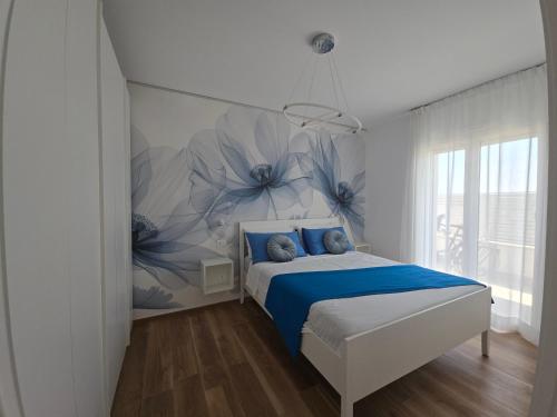 a bedroom with a bed with blue flowers on the wall at Casa Isabel Charm Apartment in San Benedetto del Tronto