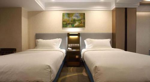 a hotel room with two beds and a painting on the wall at Dalian Bohai Pearl Hotel in Dalian