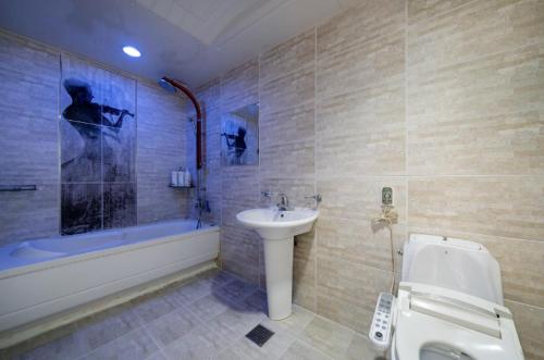 a bathroom with a sink and a tub and a toilet at Daejeon Yongjeon I Hotel in Daejeon