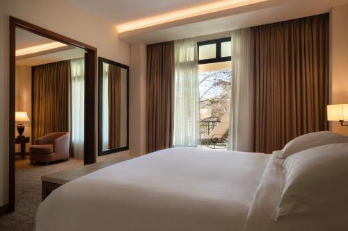 a bedroom with a large white bed and a window at Hyatt Regency Thessaloniki in Thessaloniki