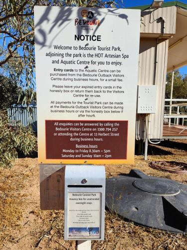 una señal frente a un edificio con una señal en Bedourie Tourist Park, 