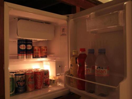 an open refrigerator filled with cans and bottles of soda at Midland Hotel in Phnom Penh