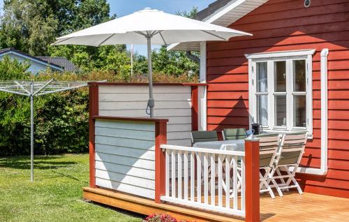 a house with an umbrella and a table and chairs at Holiday Home Egemose Sydals Iv in Skovby