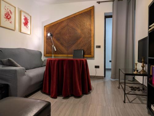 ein Wohnzimmer mit einem Tisch mit einer roten Tischdecke in der Unterkunft Dar Ar Nur Albaycin con patio in Granada